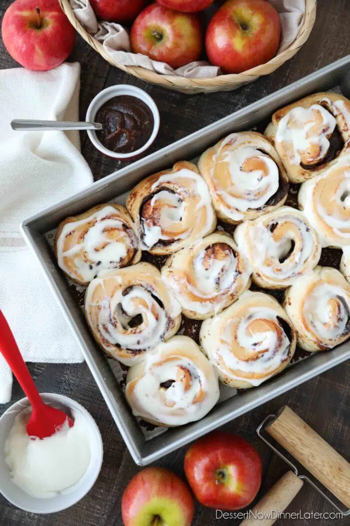 Baked Apple Butter Cinnamon Rolls in pan with cream cheese glaze.