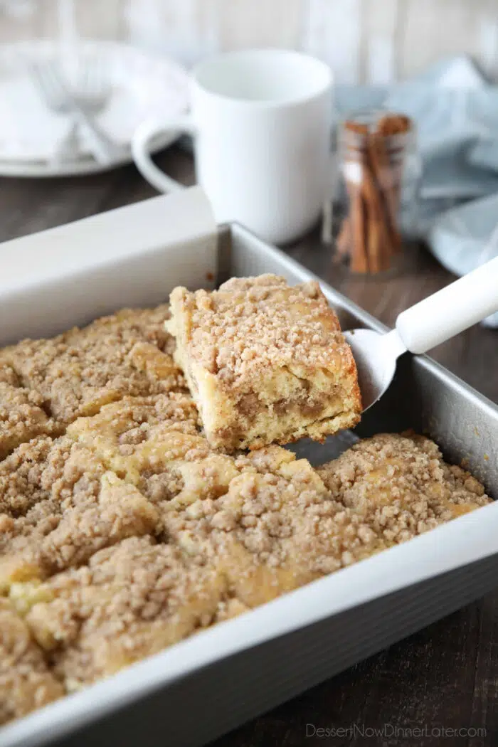 Scooping a piece of sour cream coffee cake out of the pan.