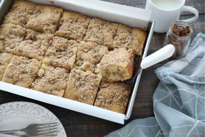 Top view of sour cream coffee cake in a 9x13 pan with a spatula underneath one slice.