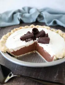 Angled view of Chocolate Cream Pie with a couple pieces taken out of the pan.