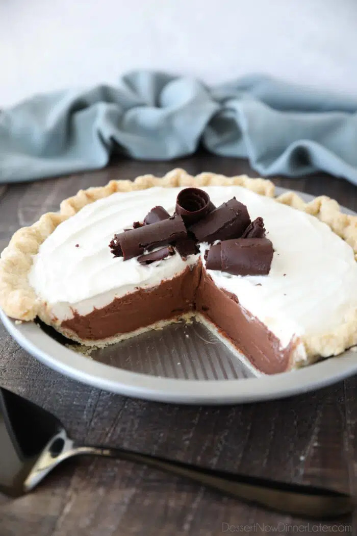 Angled view of Chocolate Cream Pie with a couple pieces taken out of the pan.