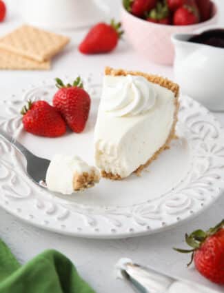 Slice of no bake cheesecake on a plate with a fork full.