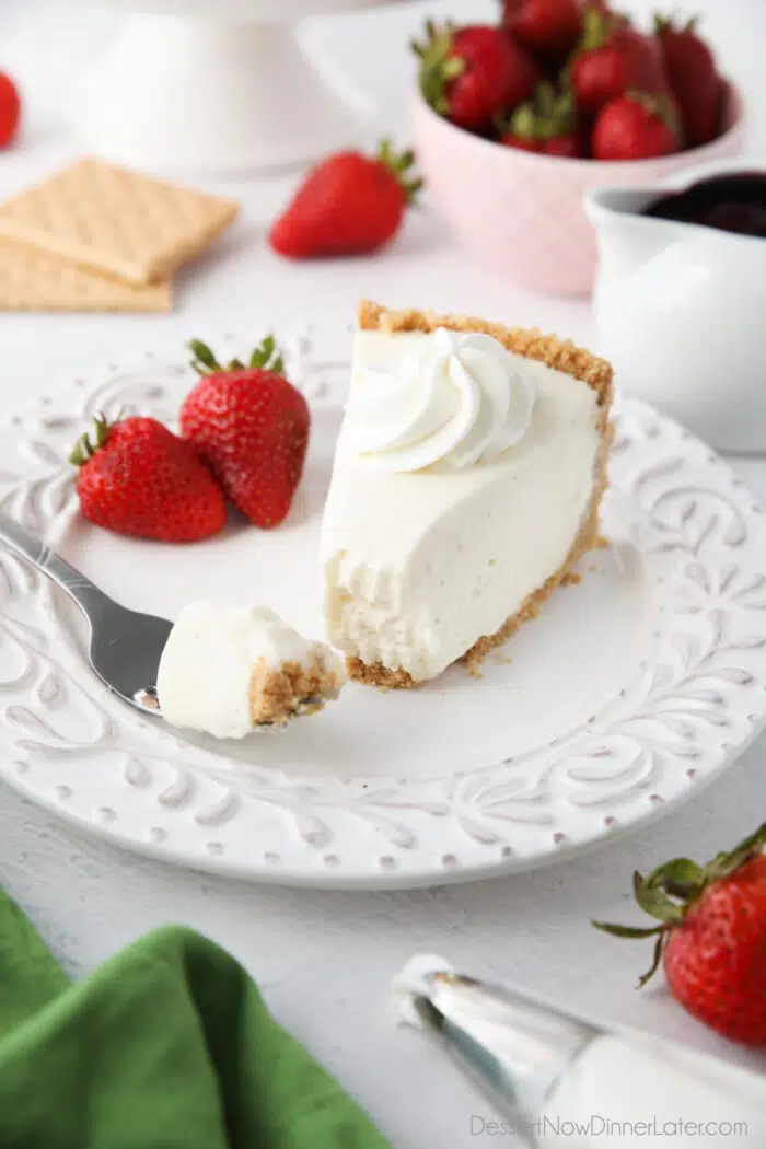 Slice of no bake cheesecake on a plate with a fork full.