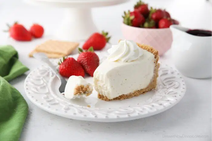 Slice of no bake cheesecake on a plate with a fork full.