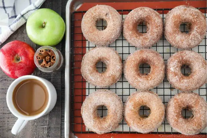 Cinnamon-sugar coated baked apple cider donuts on a cooling rack.