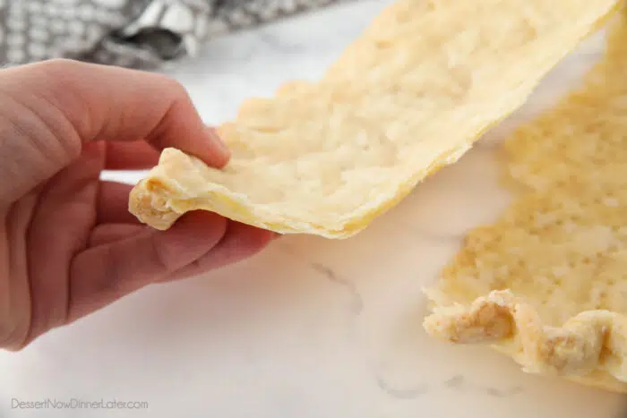 Side view of pie crust broken in half showing the flaky layers.