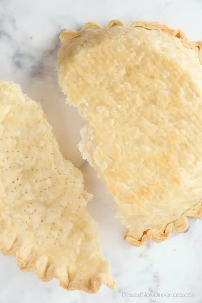 Top view of pie crust broken in half showing the flaky layers.