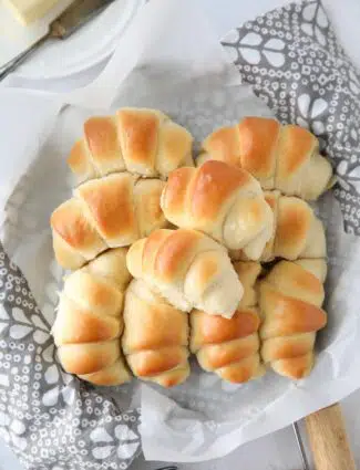 Fluffy homemade crescent rolls in a bread basket.