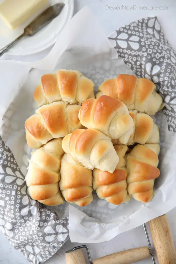 Fluffy homemade crescent rolls in a bread basket.