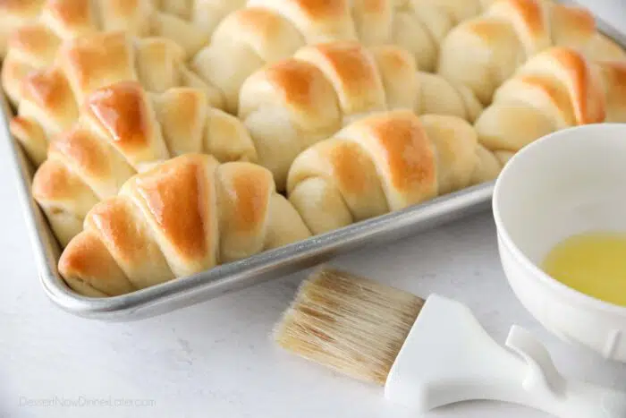 Close up of shiny butter topped crescent dinner rolls.