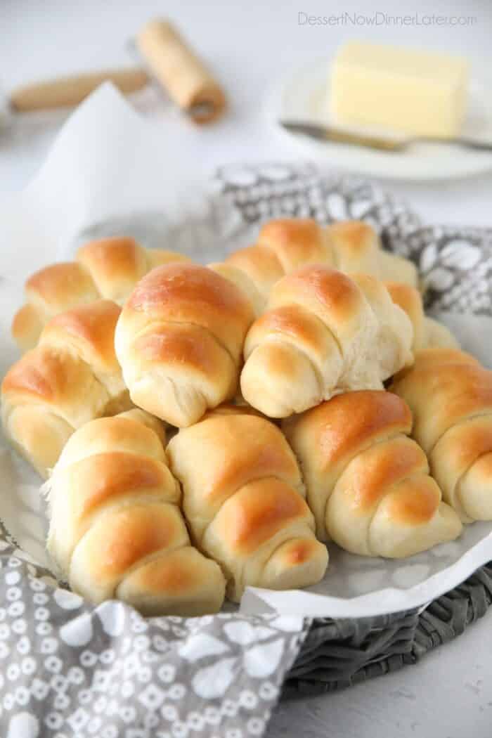 Side view of a basket full of crescent shaped dinner rolls.