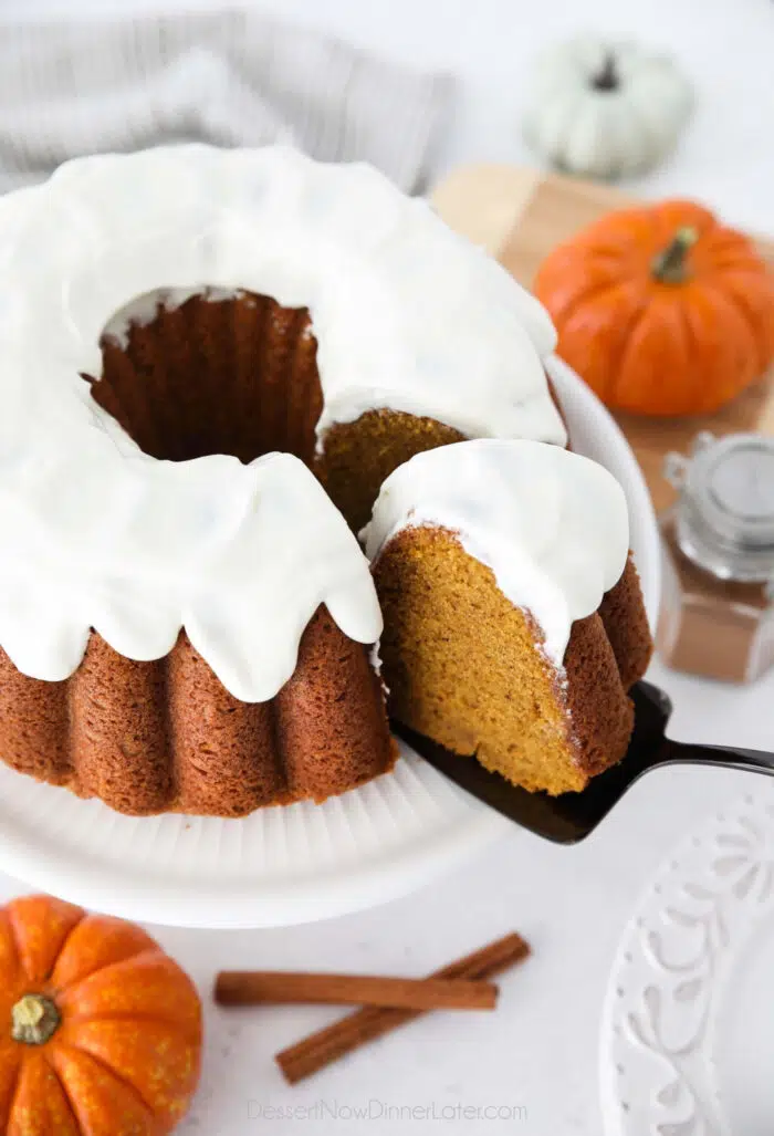 Cake server removing a slice of Pumpkin Bundt Cake with Cream Cheese Frosting