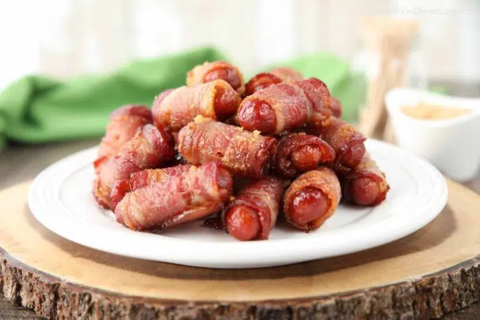 Pile of bacon wrapped smokies on a plate.