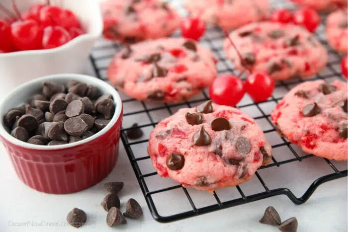 Side view of chocolate chip cherry cookies on a cooling rack.