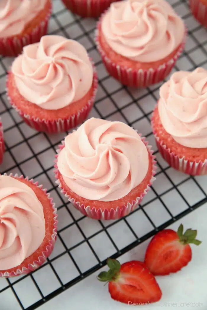 Strawberry cupcakes with strawberry cream cheese frosting piped on top.