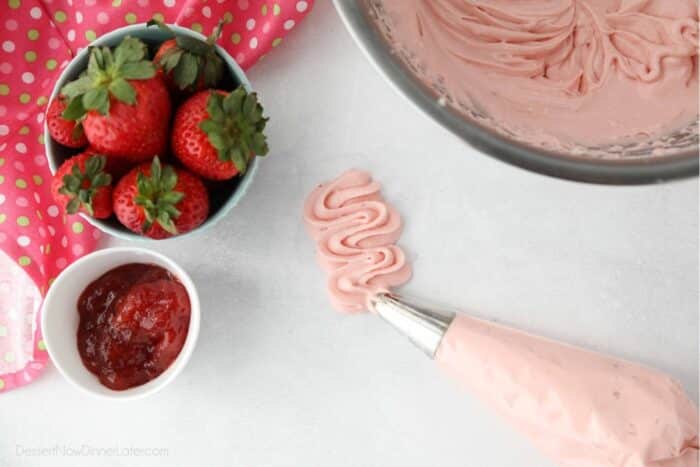 Strawberry cream cheese frosting piped onto surface with a pastry bag and tip.