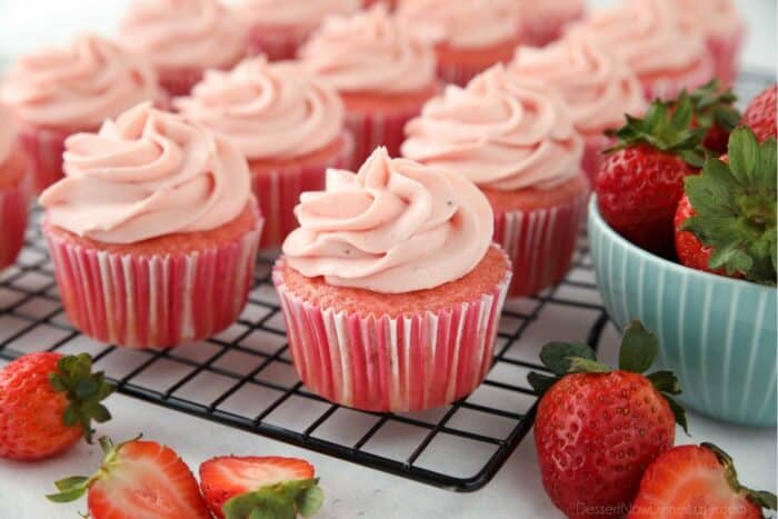 Frosted strawberry cupcakes on a wire cooling rack.