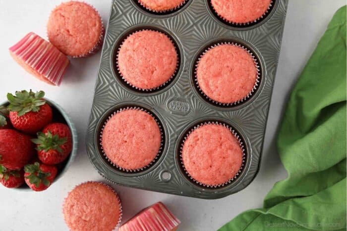 Baked strawberry cupcakes in a muffin pan.