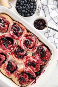 Top view of a baking dish full of blueberry cinnamon rolls.