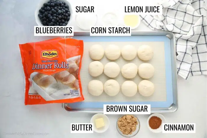 Labeled ingredients for blueberry cinnamon rolls: blueberries, sugar, corn starch, lemon juice, Rhodes dinner rolls, butter, brown sugar, and cinnamon.