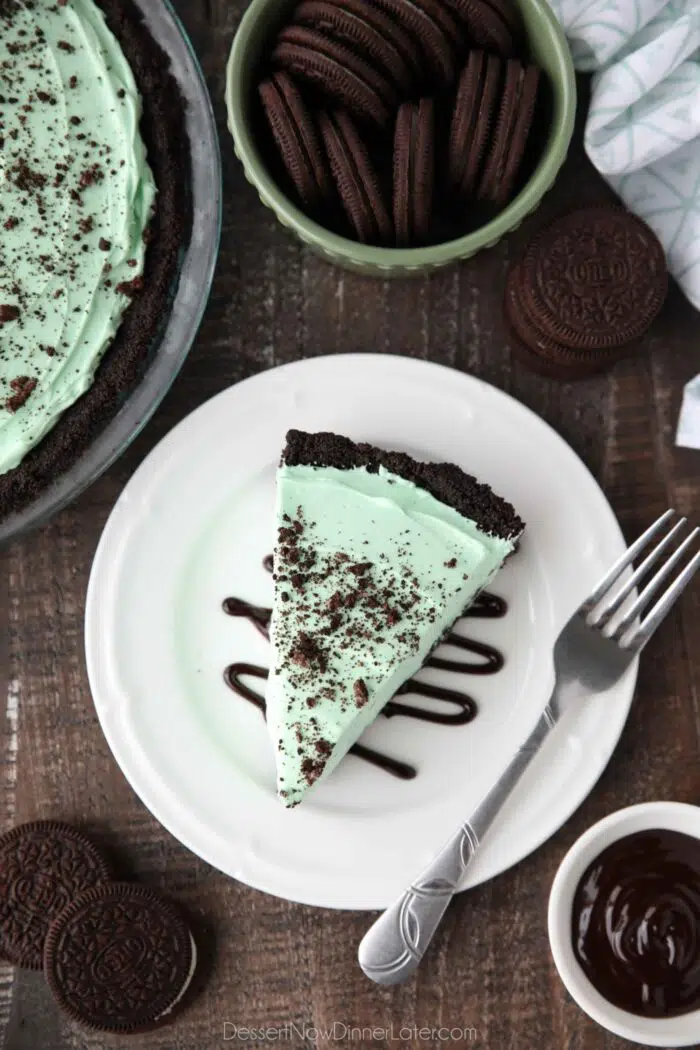 Top view of a slice of no-bake grasshopper pie sitting on a drizzle of chocolate sauce.
