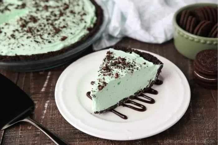Side view of grasshopper pie on a plate with chocolate sauce.