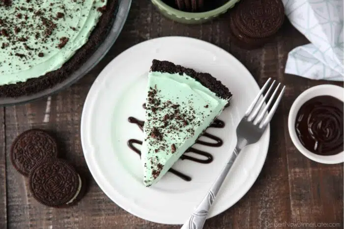 Top view of a slice of no-bake grasshopper pie sitting on a drizzle of chocolate sauce.