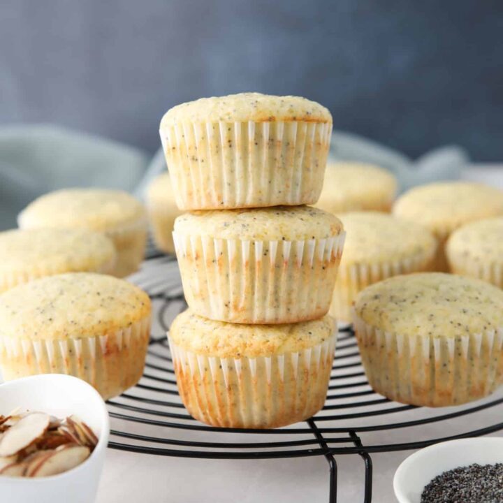 Almond Poppy Seed Muffins stacked on top of each other.