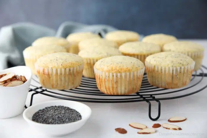 Side view of almond poppy seed muffins resting on a wire cooling rack.