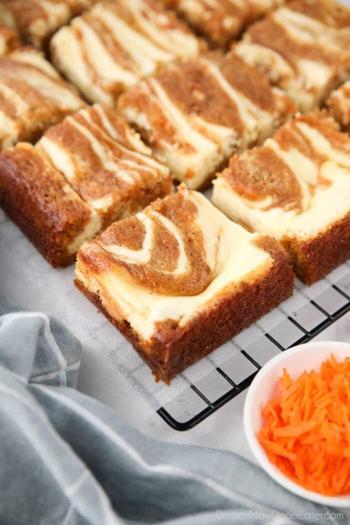 Squares of carrot cake cream cheese bars.
