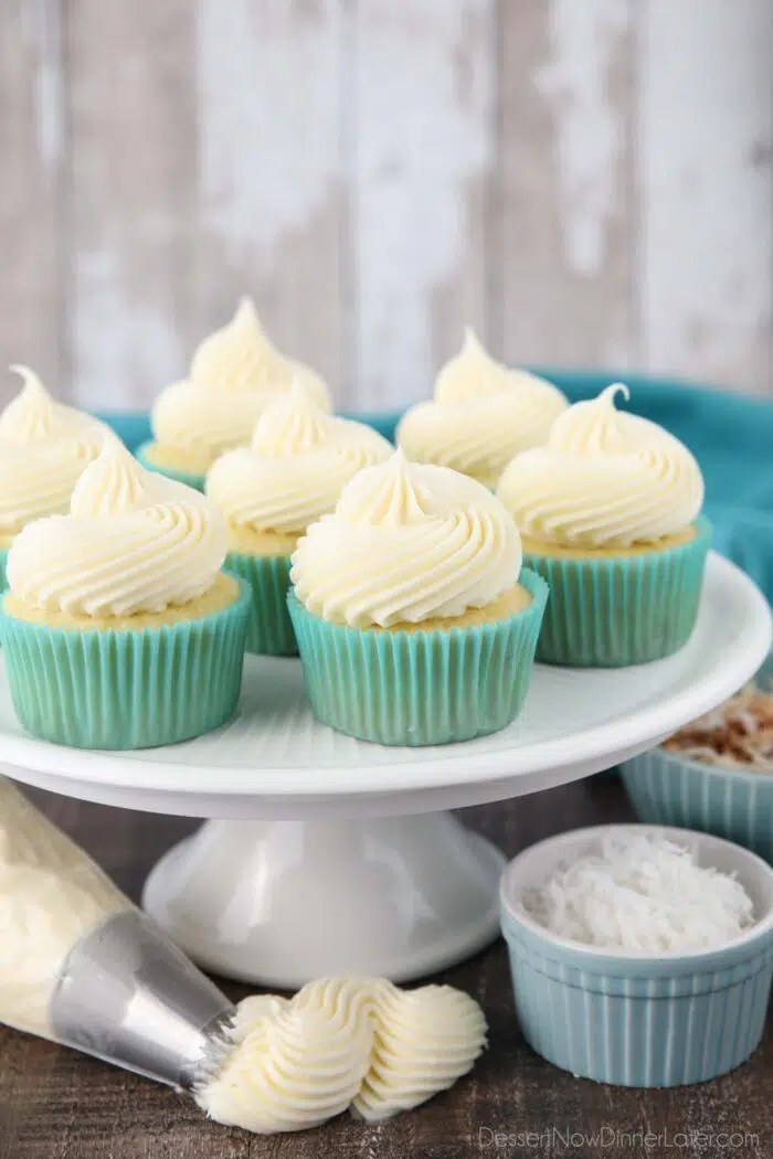 Big swirls of coconut cream cheese frosting piped onto cupcakes.