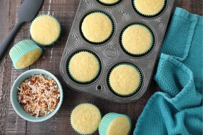 Top view of cupcake tin with baked coconut cupcakes.