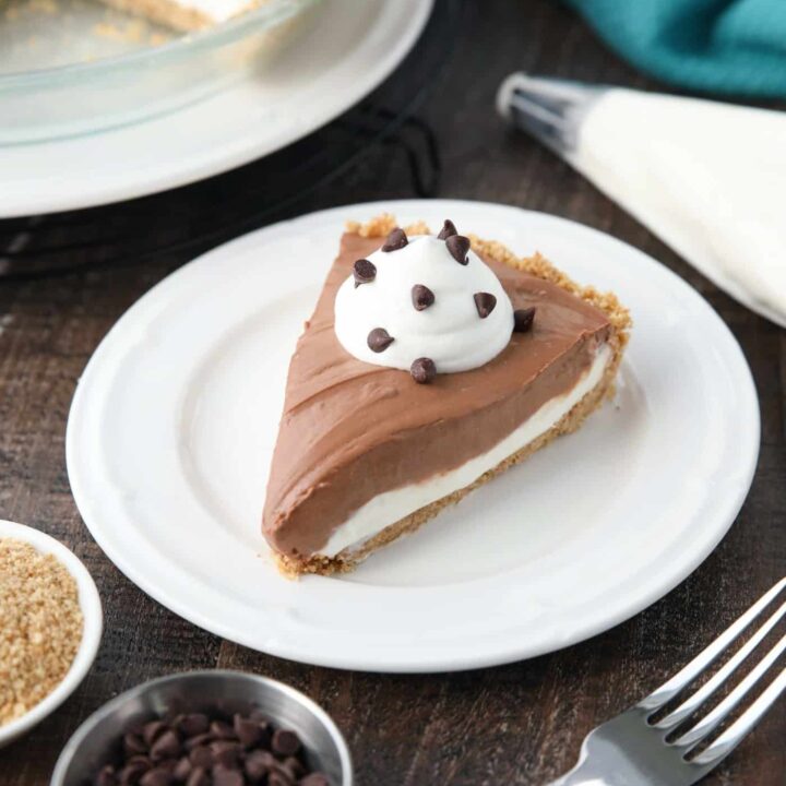 Slice of Chocolate Cream Cheese Pie on a plate with whipped cream and mini chocolate chips.