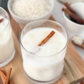 Close-up view of Mexican horchata in a cup with ice and a cinnamon stick.