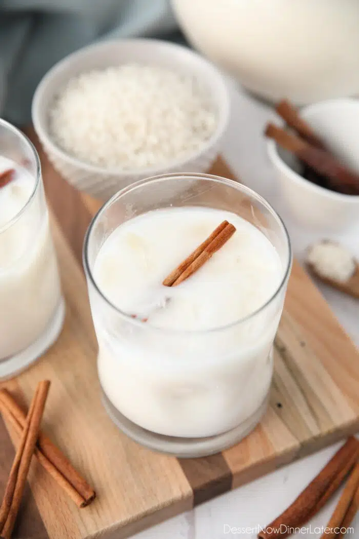 Close-up view of Mexican horchata in a cup with ice and a cinnamon stick.