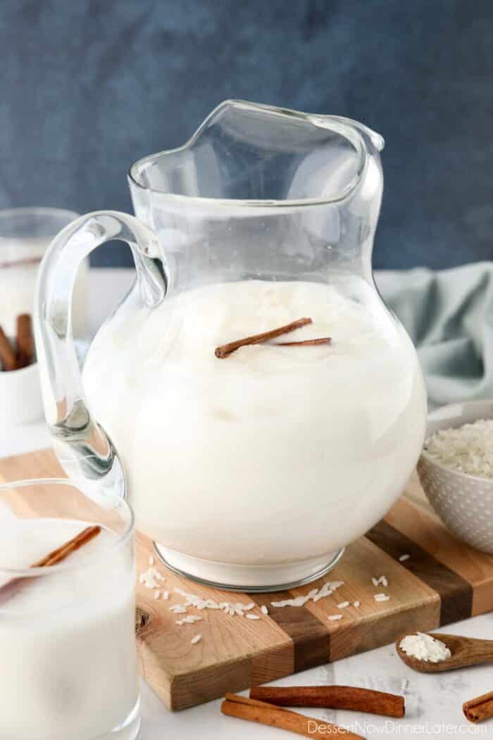 Pitcher of Mexican horchata with ice and cinnamon sticks.