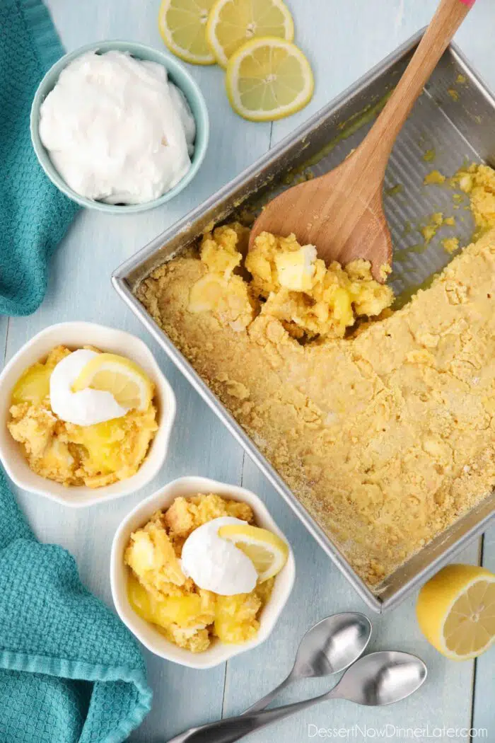 Pan of baked lemon dump cake and two individual bowls of it ready to be eaten.