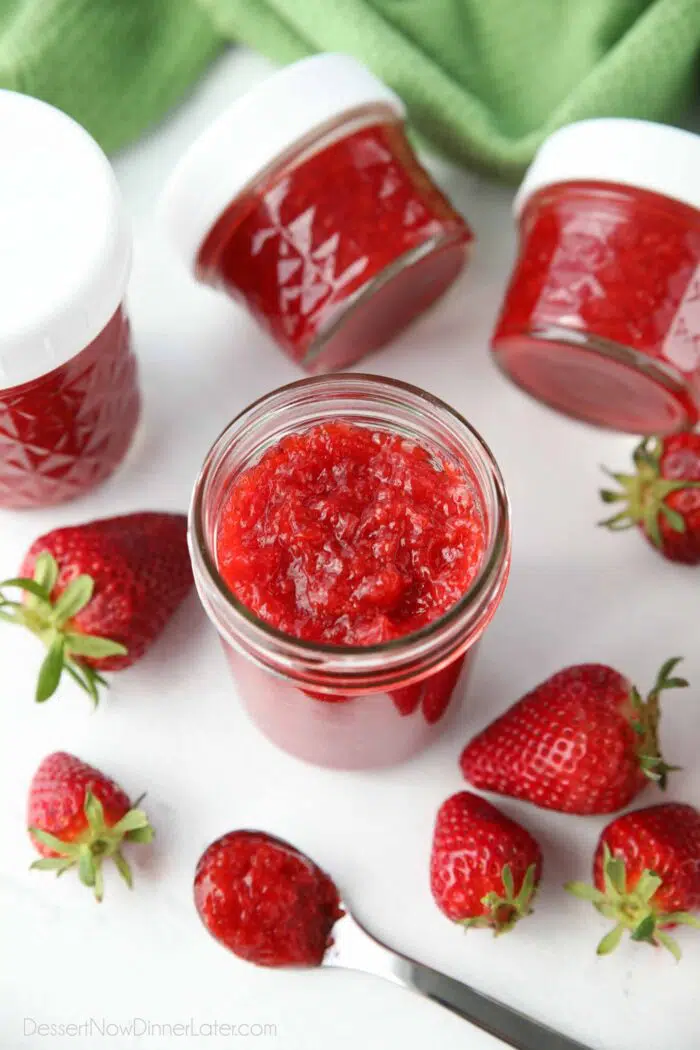 An open jar of thick strawberry freezer jam.