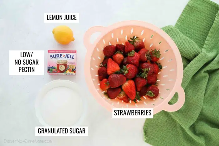 Ingredients for low-sugar strawberry freezer jam. Strawberries, granulated sugar, low/no sugar pectin, and lemon juice.