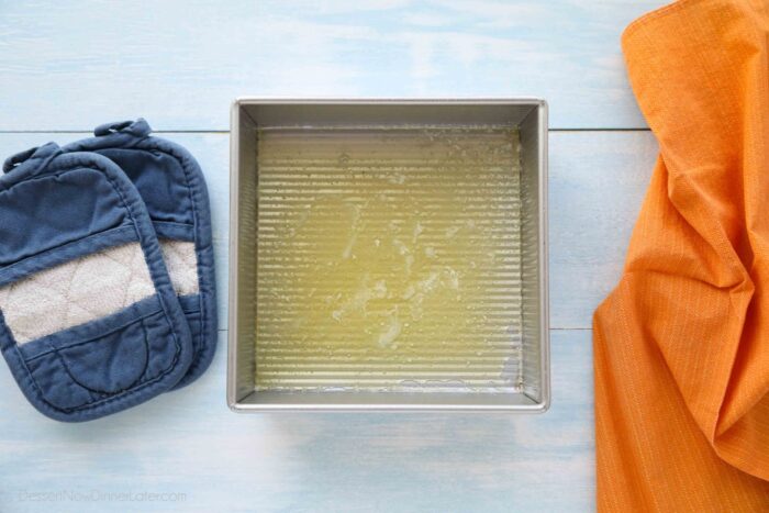Melted butter in a square baking pan.
