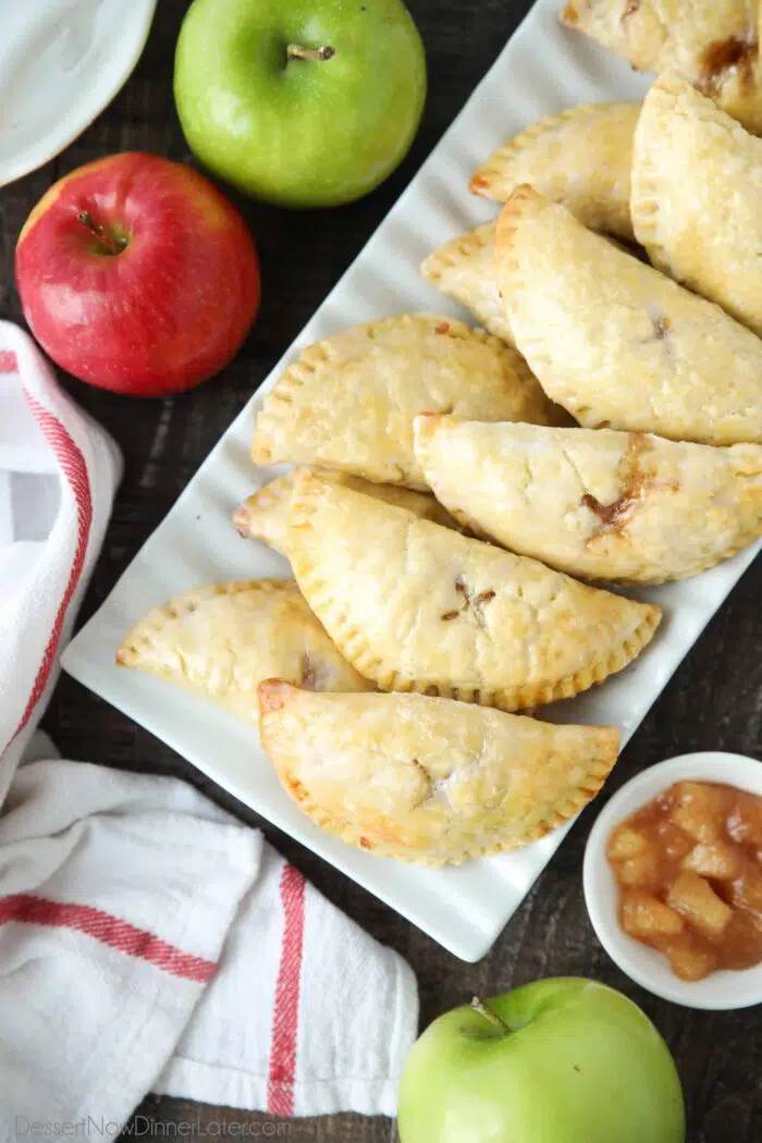 Glazed mini apple pies on a serving platter.