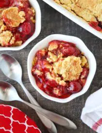 Bowl full of cherry dump cake made with cherry pie filling, cake mix, and butter.