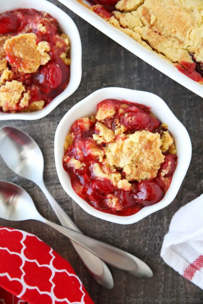 Bowl full of cherry dump cake made with cherry pie filling, cake mix, and butter.