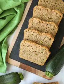 Slices of soft zucchini bread on a serving platter.