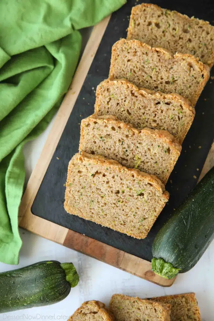 Slices of soft zucchini bread on a serving platter.