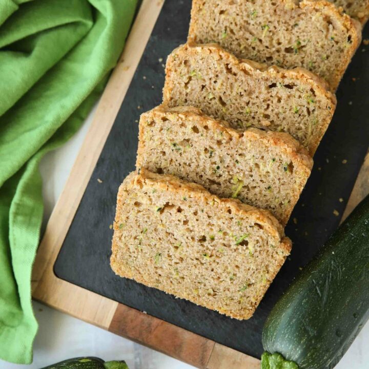 Slices of soft zucchini bread on a serving platter.