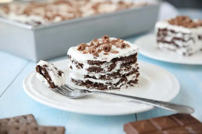 Icebox Cake with layers of chocolate graham crackers and whipped cream with chocolate curls on top.