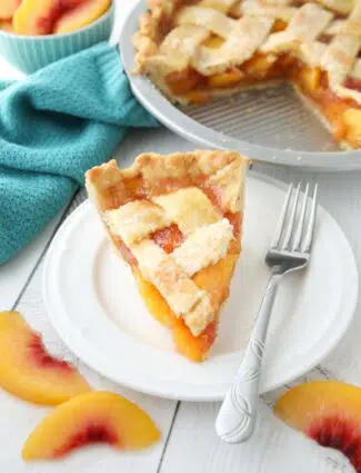 Slice of peach pie made with frozen peaches on a plate.