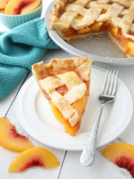 Slice of peach pie made with frozen peaches on a plate.