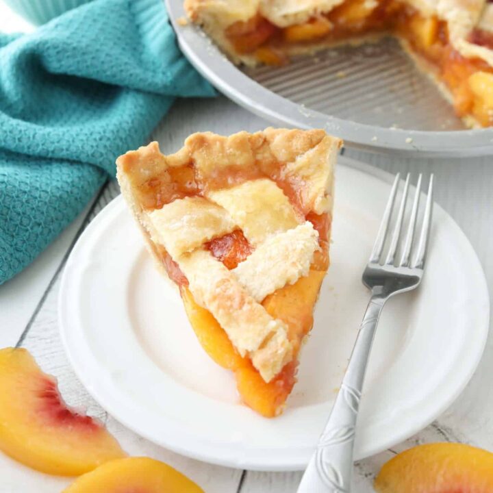 Slice of peach pie made with frozen peaches on a plate.